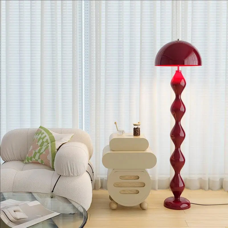 Lampadaire Rimo rouge à côté d'un fauteuil
