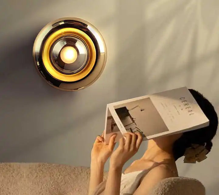 Applique Orbo installée au-dessus d'une tête de lit